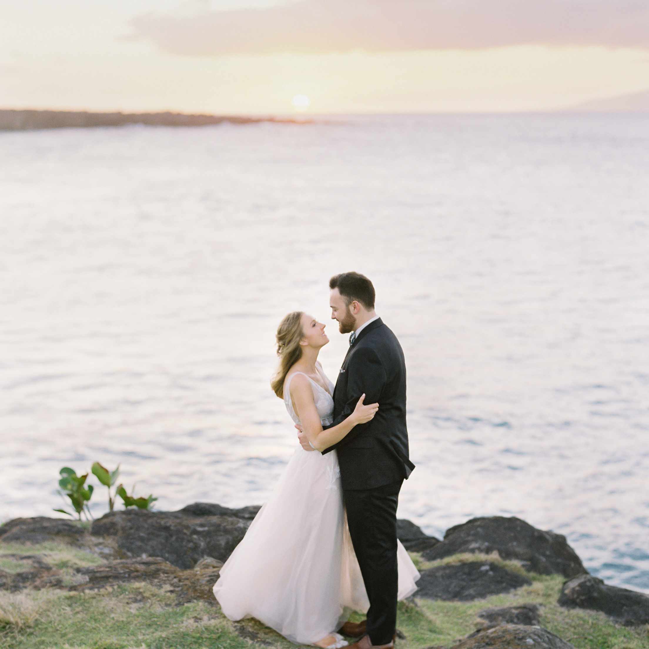 热带毛伊岛婚礼，新娘和新郎拥抱日落