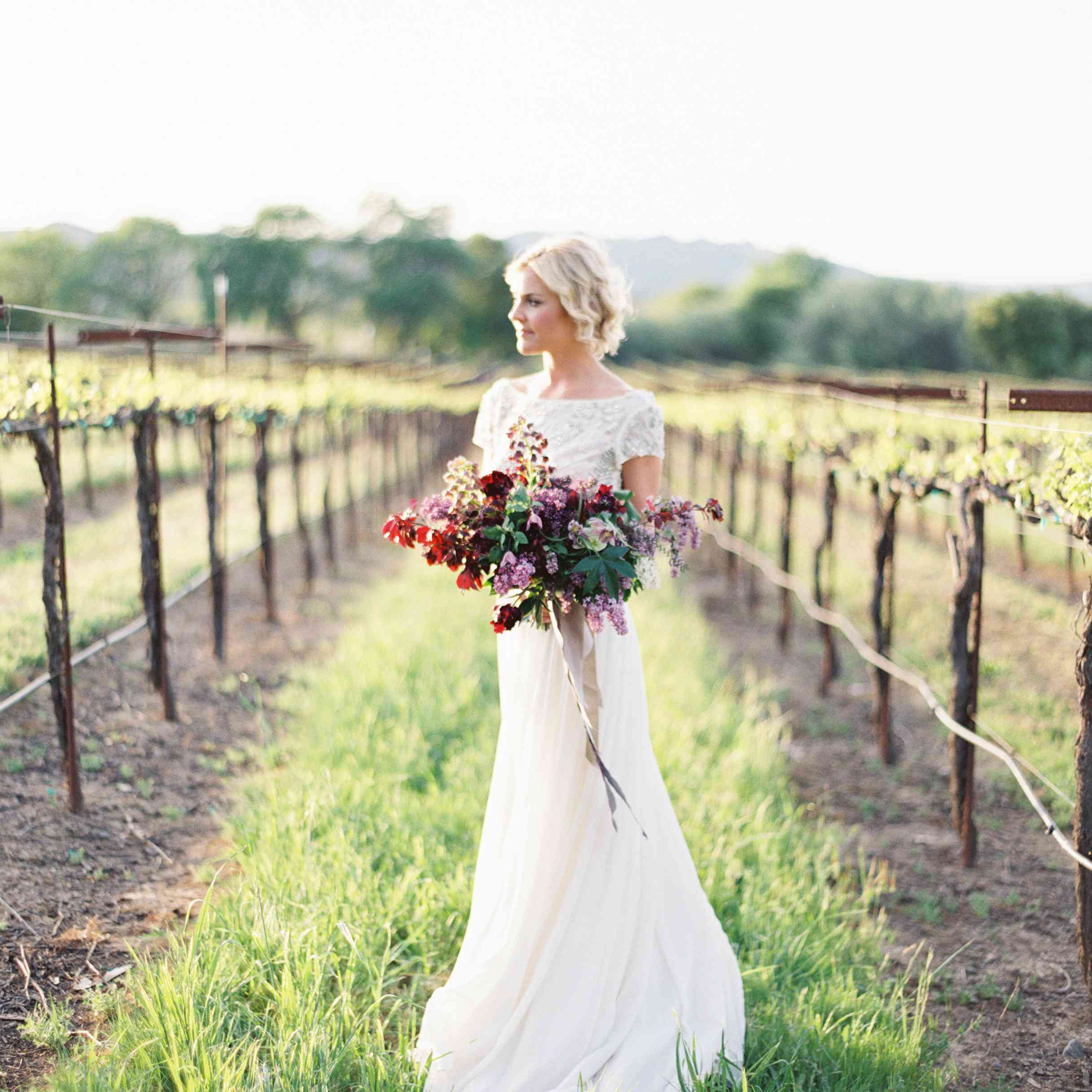 一个新娘手捧花束“class=