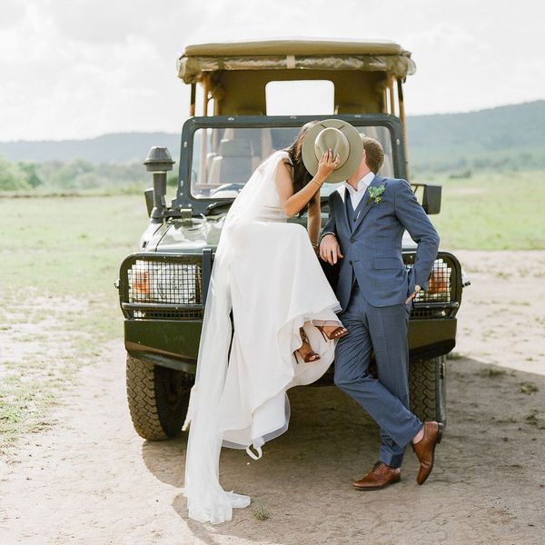 亲吻在徒步旅行队帽子后的新娘和新郎