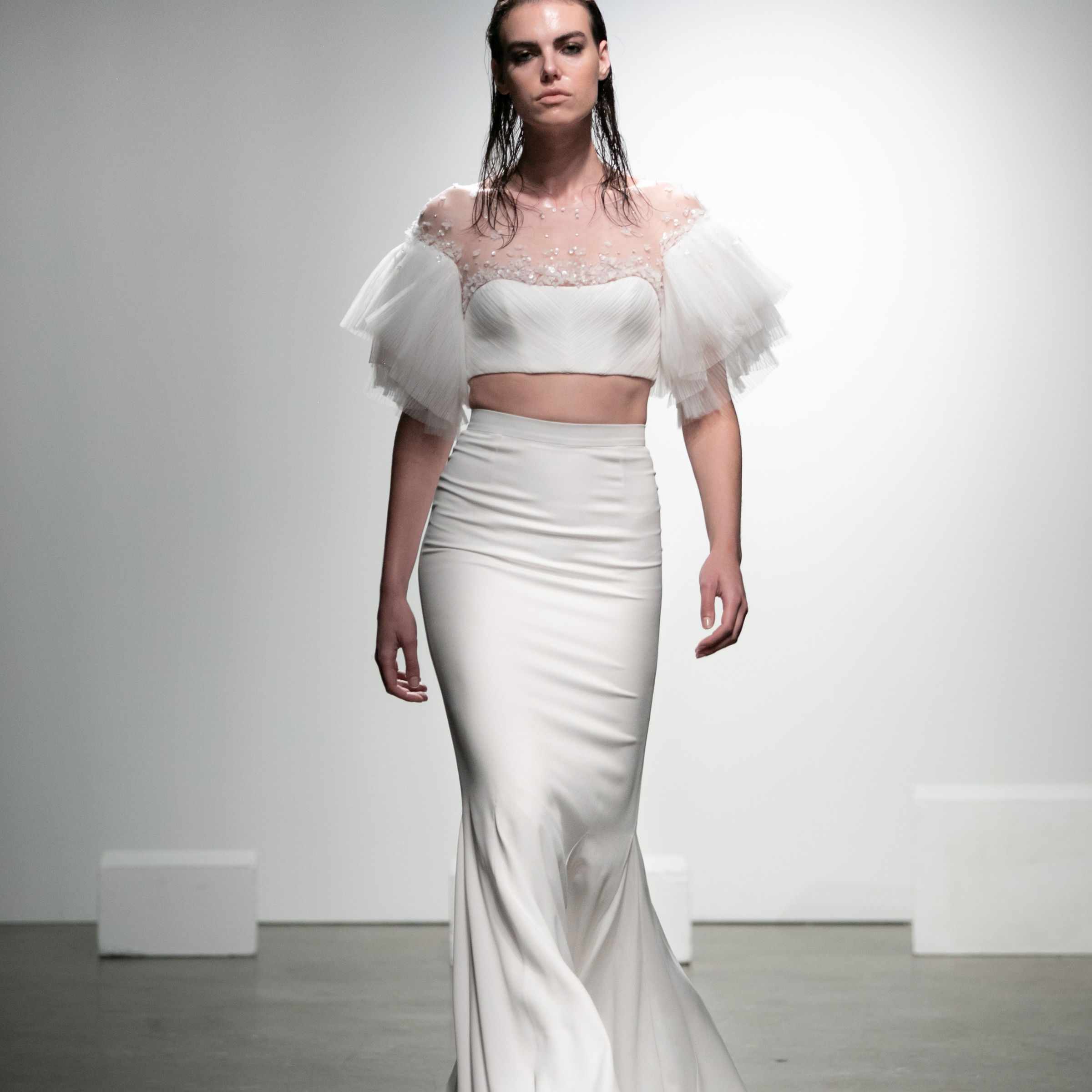 模特露脐上衣与薄纱袖子和刺绣薄纱领口和长裙