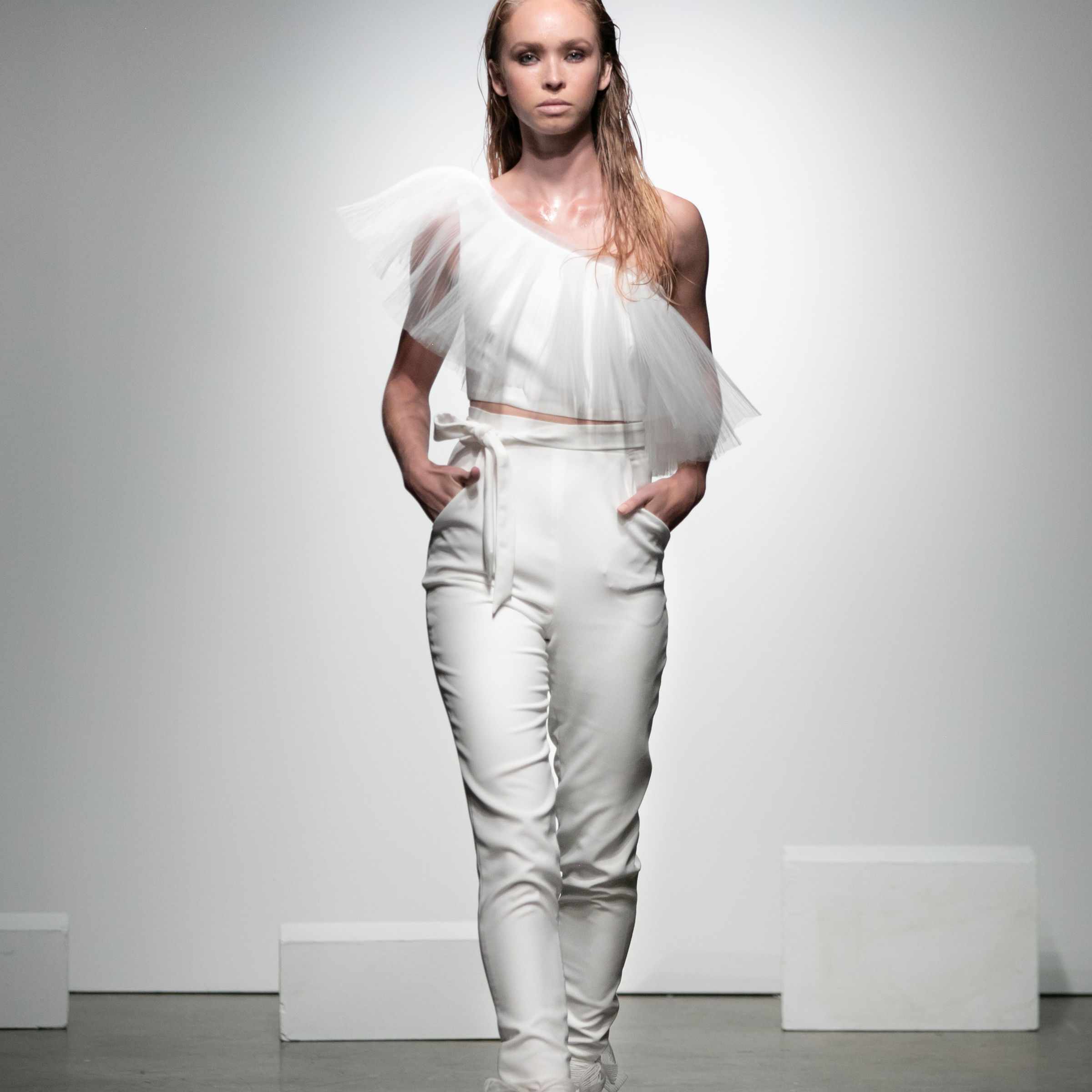 模特身穿两件套连身衣，上身不对称的薄纱