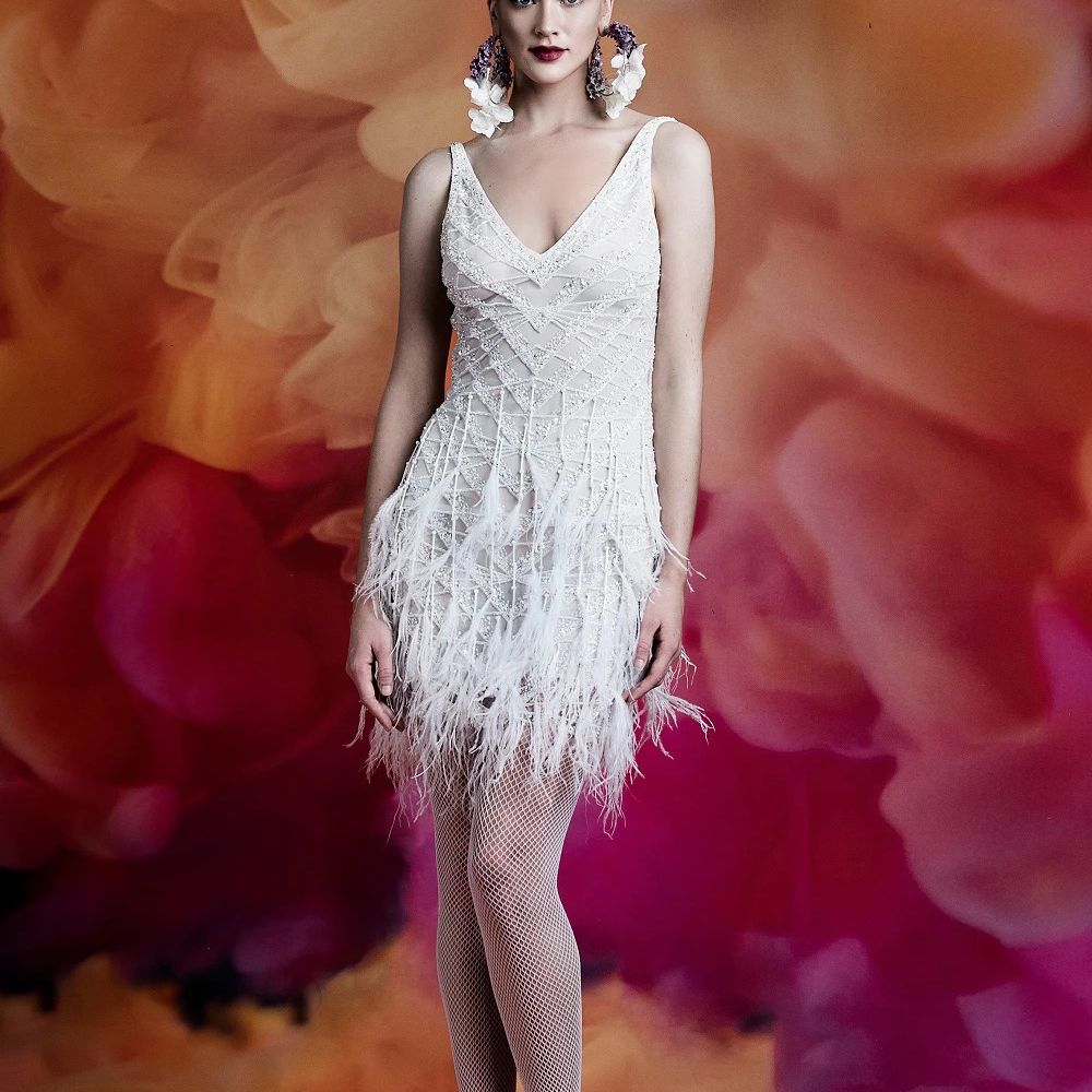 身穿v领绣花短裙配羽毛裙的模特