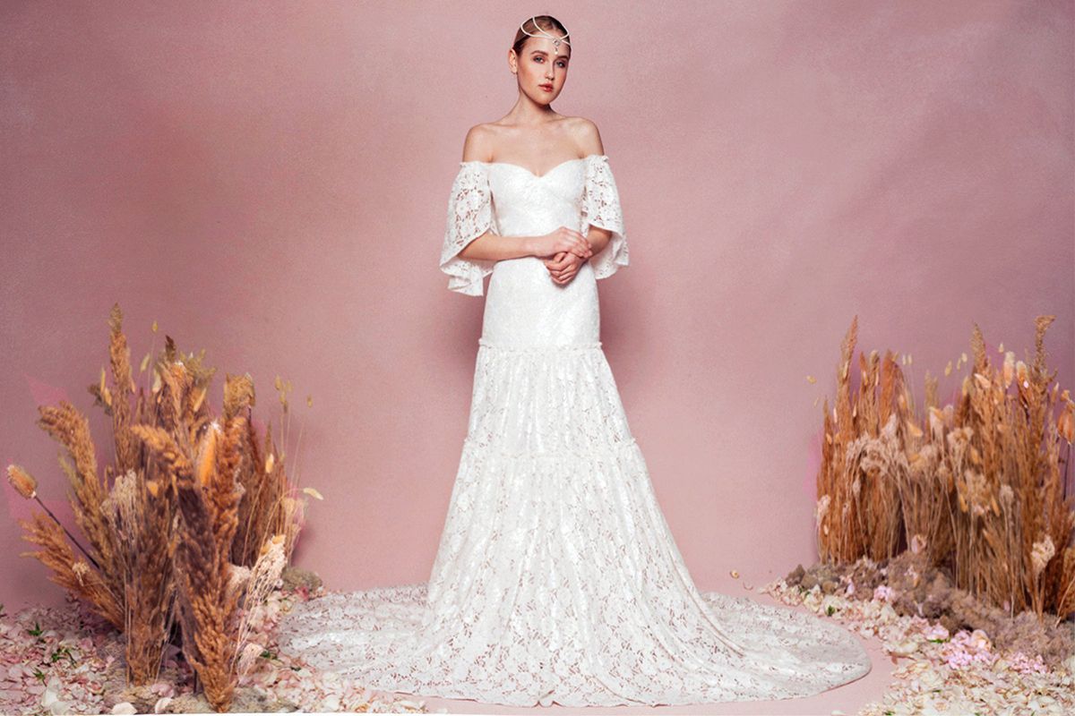 模特身着蕾丝露肩礼服，飘动的袖子和分层裙