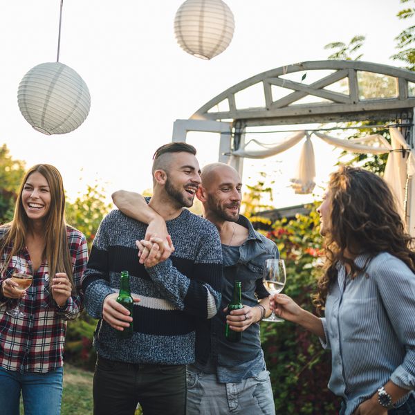 两个订婚的男人在户外派对上和客人交谈