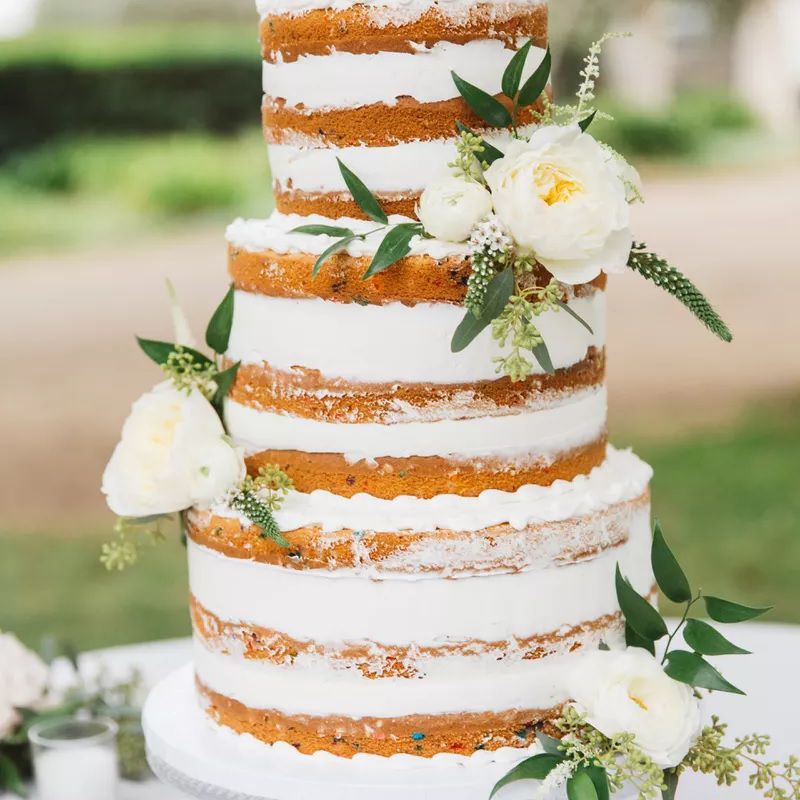 高大的白色分层裸露蛋糕与白色的花朵