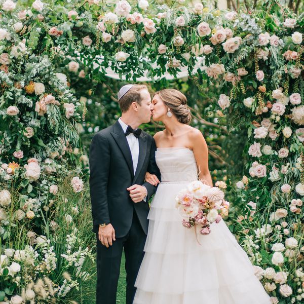 在花拱下的新娘和新郎亲吻