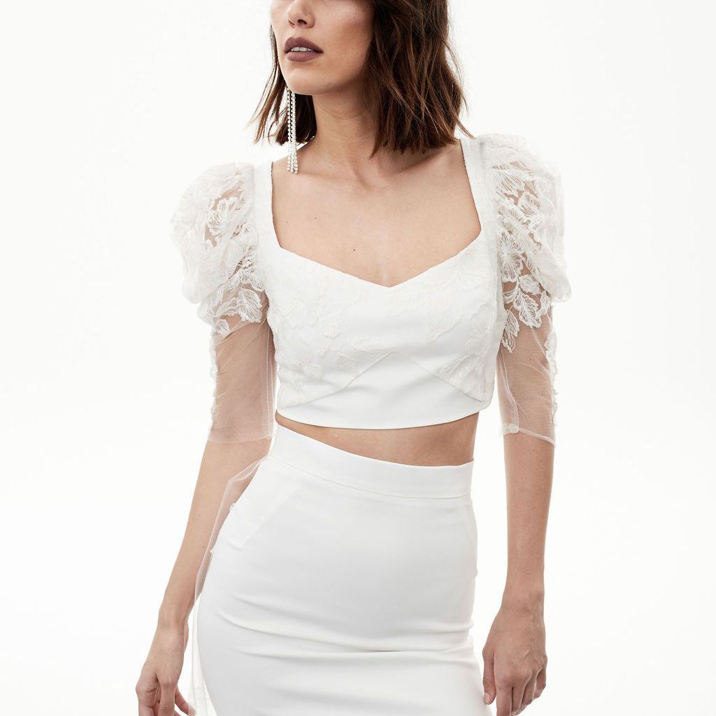 模特穿着露脐上衣，蕾丝袖和合身的长裙