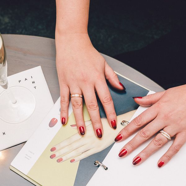 女子手红指甲和香槟玻璃