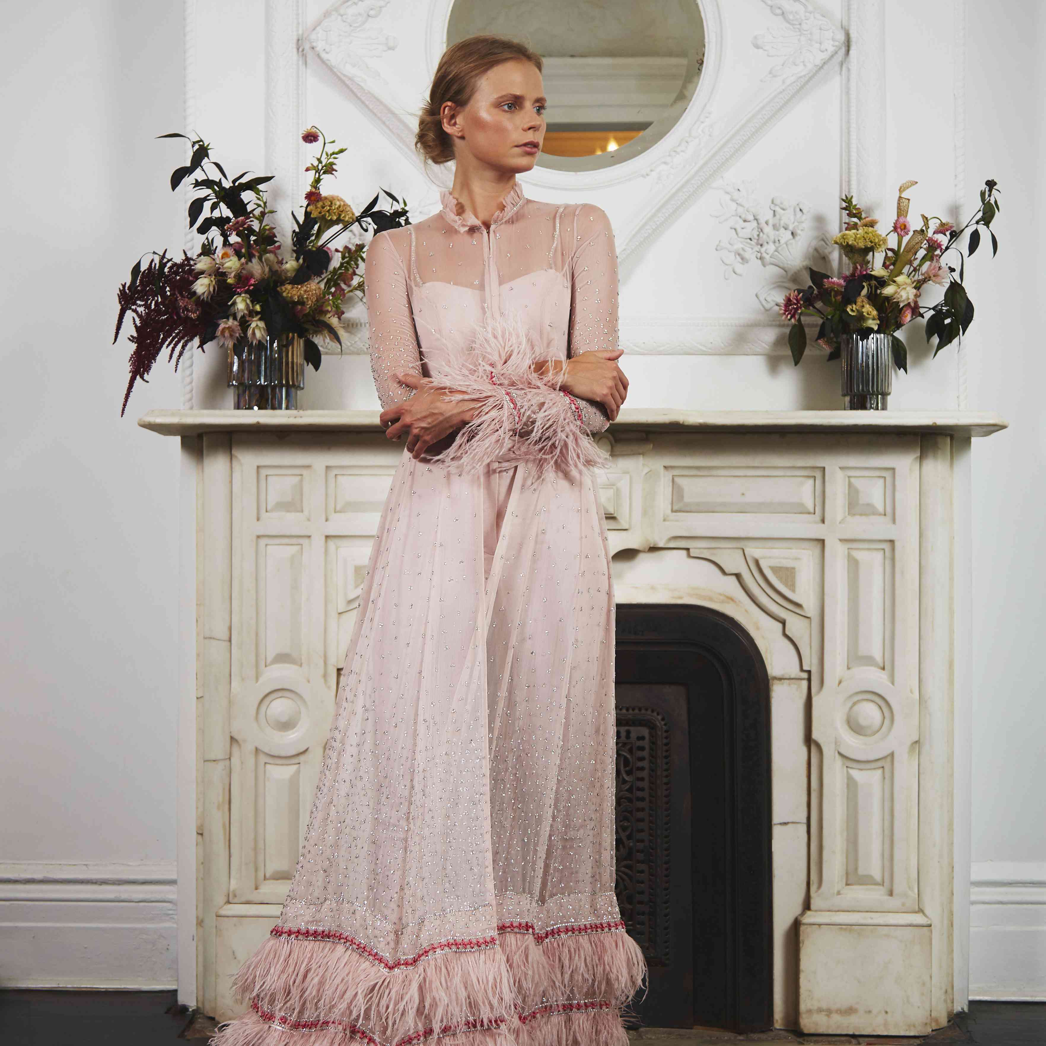 身着粉红色长袖饰有羽毛边的长衫的模特