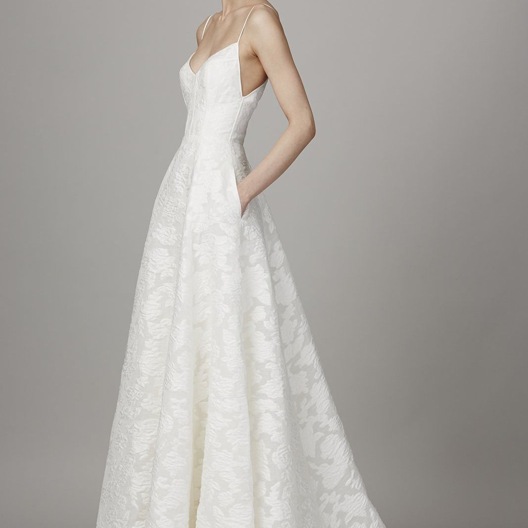 模特身着带口袋的白色细面条带长婚纱