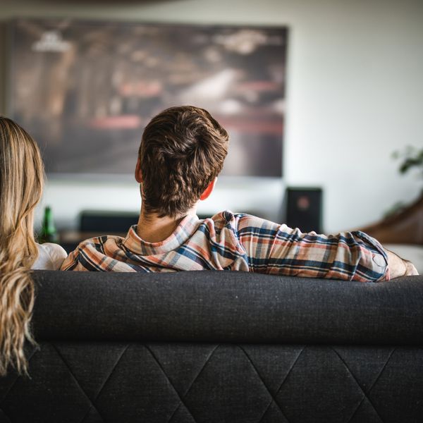 在家看在沙发的一对夫妇的后面观点。