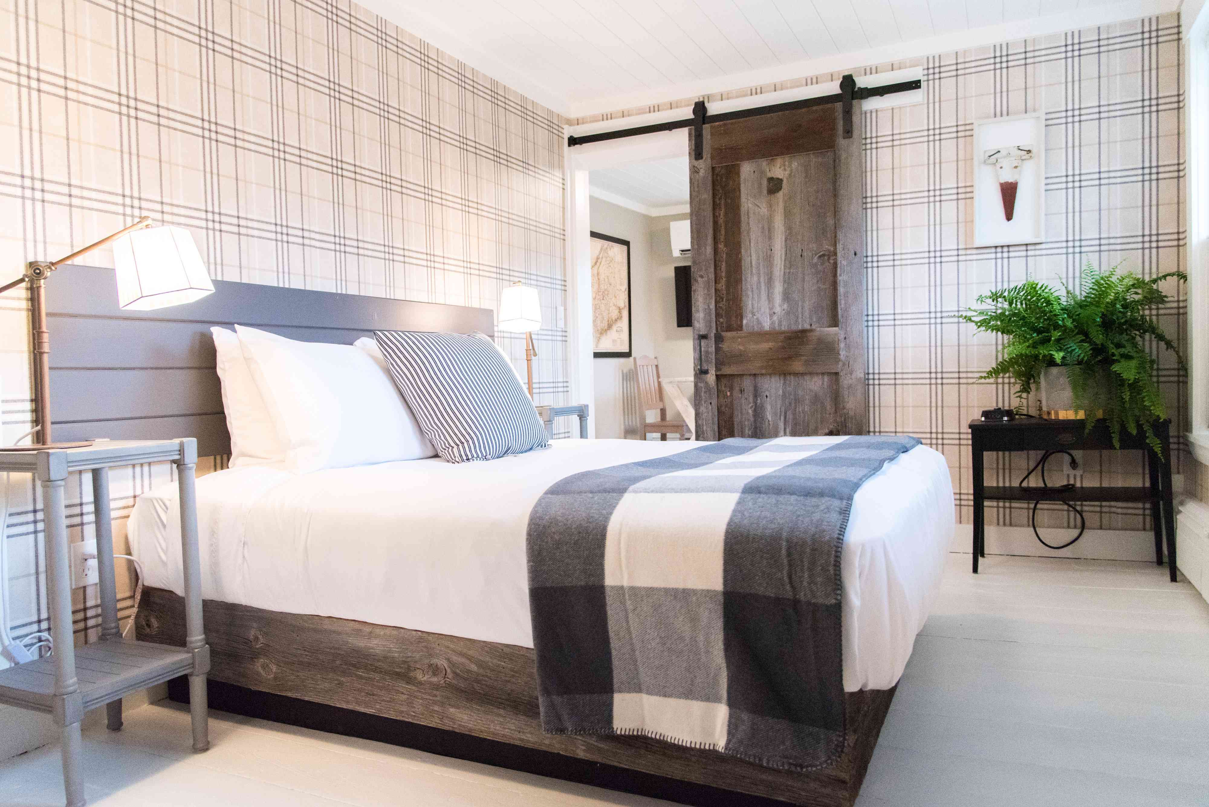 有谷仓门和格子壁纸的酒店房间