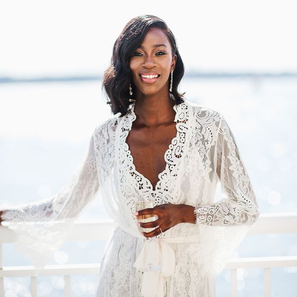 海滨阳台上穿着长袍的微笑新娘