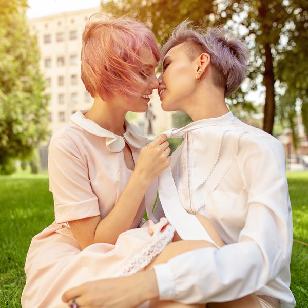 亲吻在公园的女同性恋的夫妇侧视图。