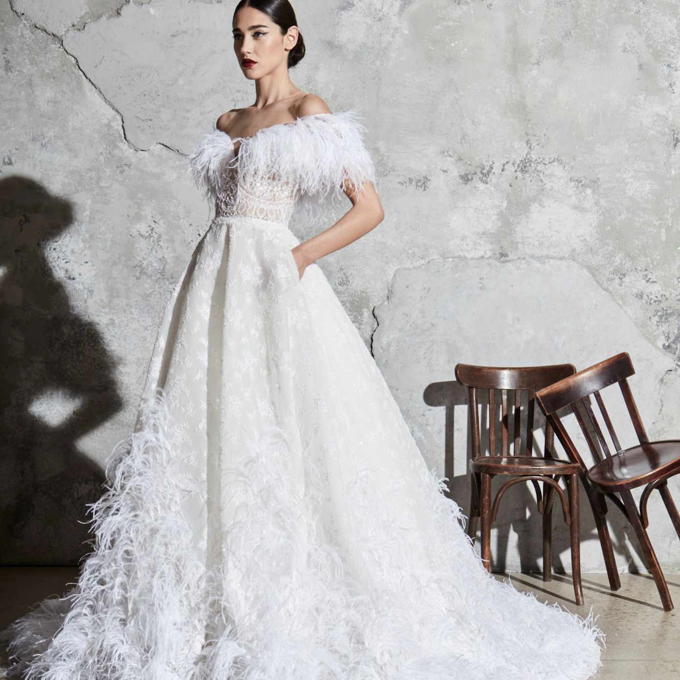 模特穿着领口有鸵鸟羽毛细节的露肩舞会礼服，一件绣花上衣，和一件下摆有鸵鸟羽毛细节的碎花裙子