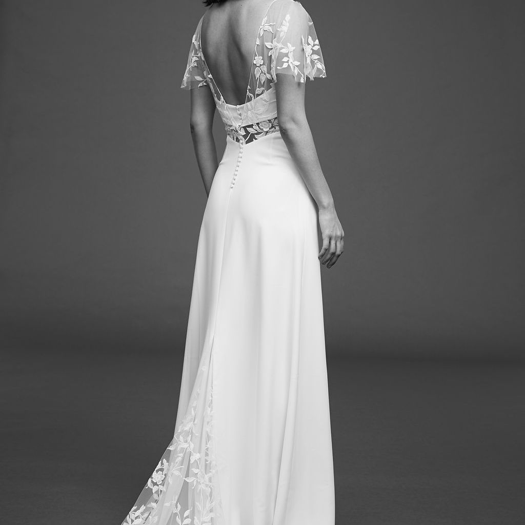 模特在绉连衣裙与绣花薄纱和蝴蝶袖子