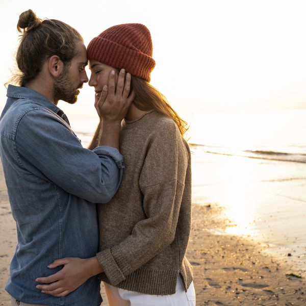 夫妇拥抱在海滩的在日落