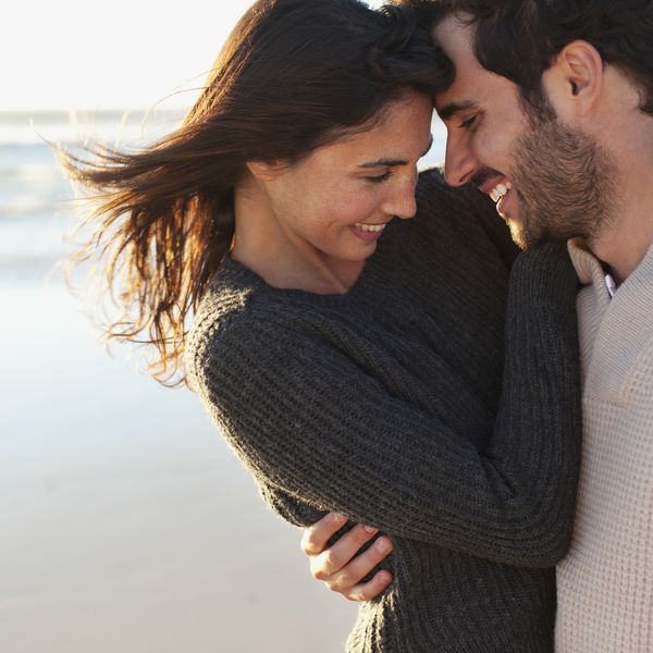 男人和女人在海滩上微笑和拥抱