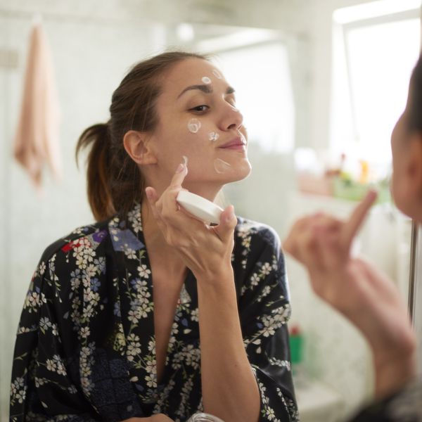 女人在浴室的镜子前涂面霜