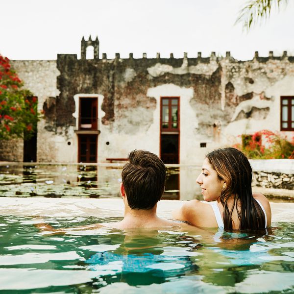 在游泳池的一对夫妇看一个人的妇女，谁看着远离她