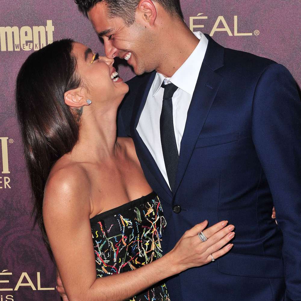 莎拉·海兰德和威尔斯·亚当斯在红毯上微笑着擦鼻子。