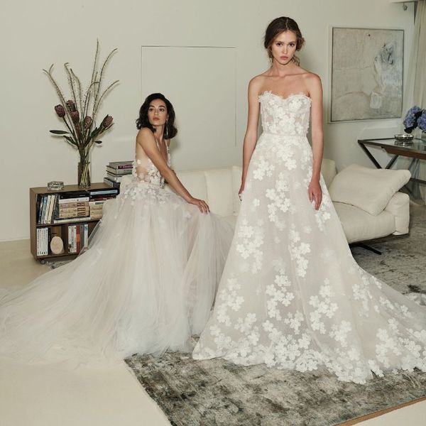 一个穿着婚纱坐在客厅里，一个穿着婚纱站在客厅里