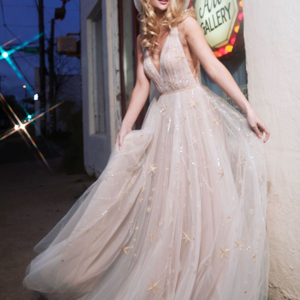 模特在v领薄纱舞会礼服与流星刺绣和珠