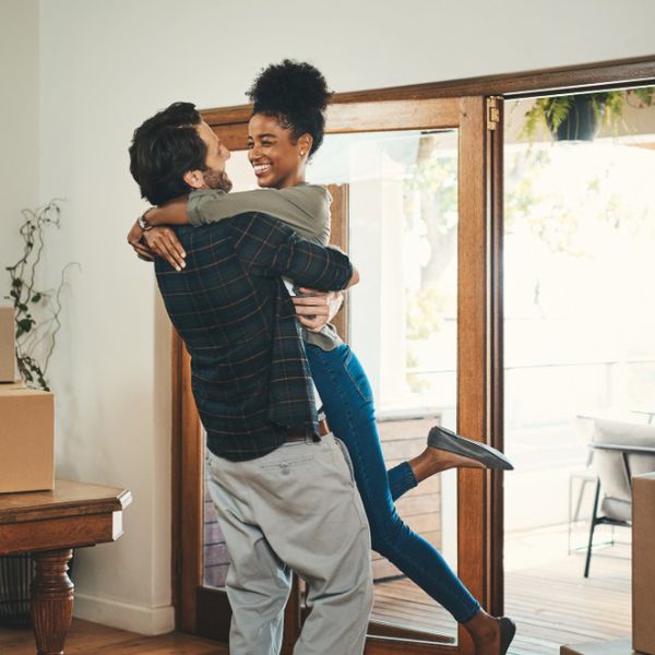 深情的中年男子抬起他的妻子在庆祝他们的新家园