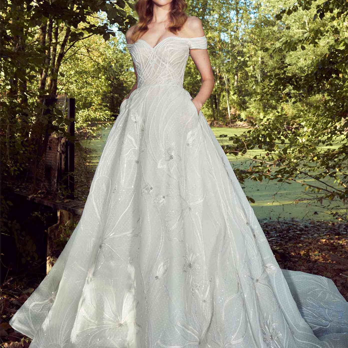 模特在露肩甜心点薄纱舞会礼服与银珠刺绣和裙子口袋