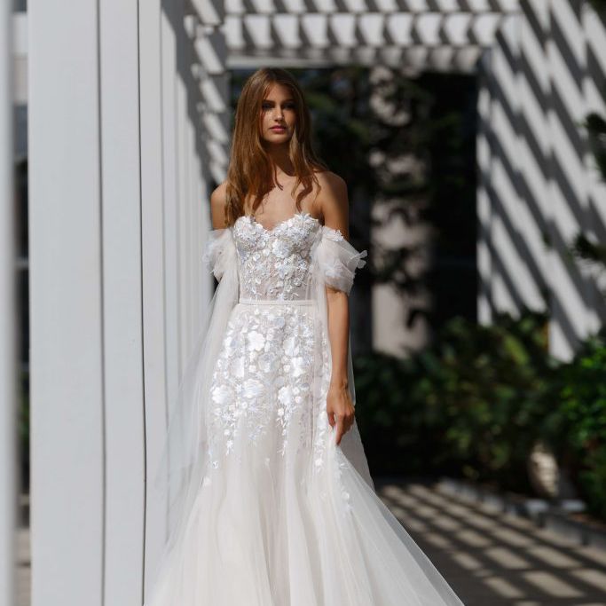 模特穿着无肩带绣花花边和薄纱垂袖礼服