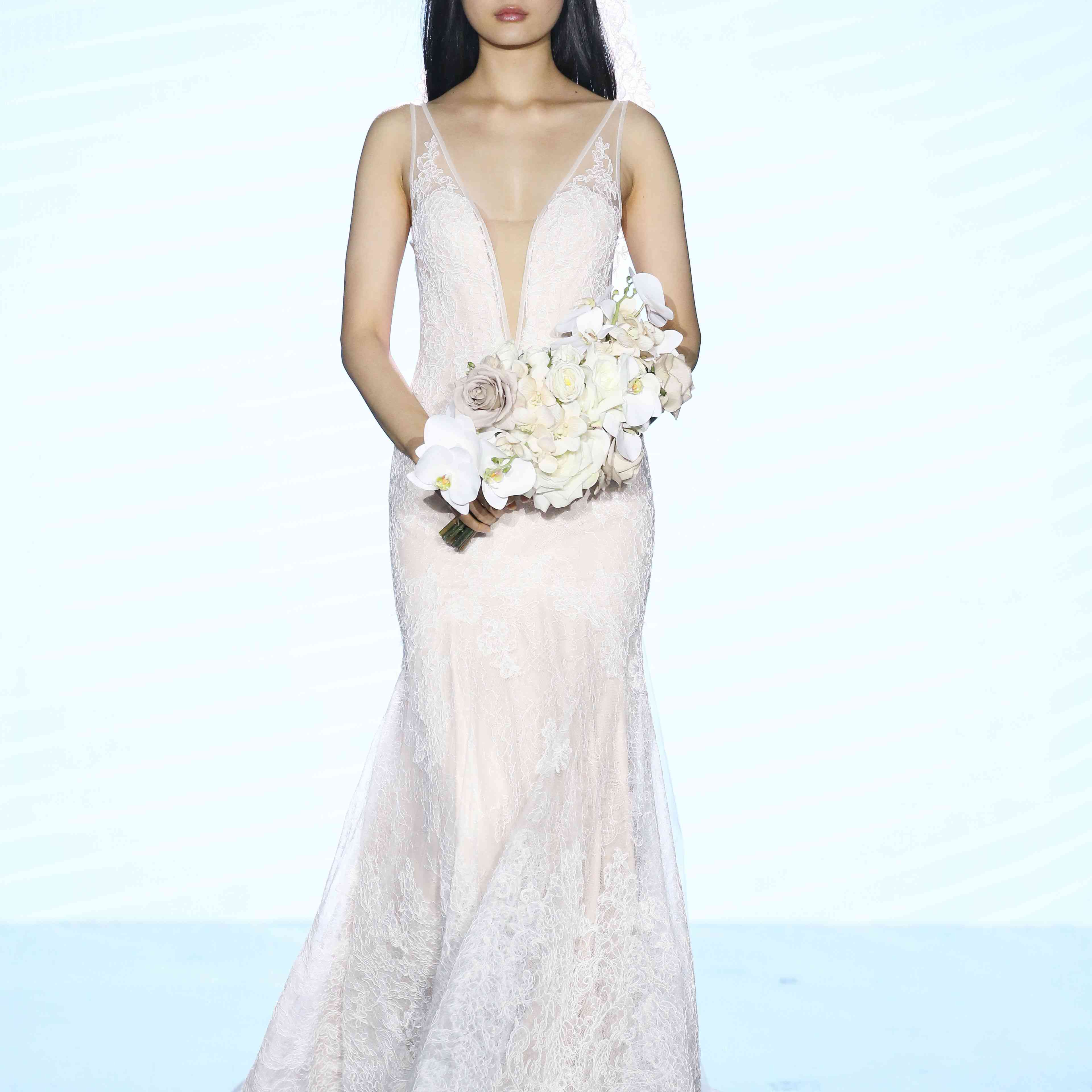 模特在fit-and-flare全身蕾丝婚礼礼服与深v错觉领口