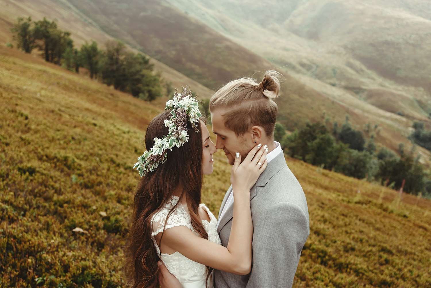 新娘捧着新郎的脸站在山坡上