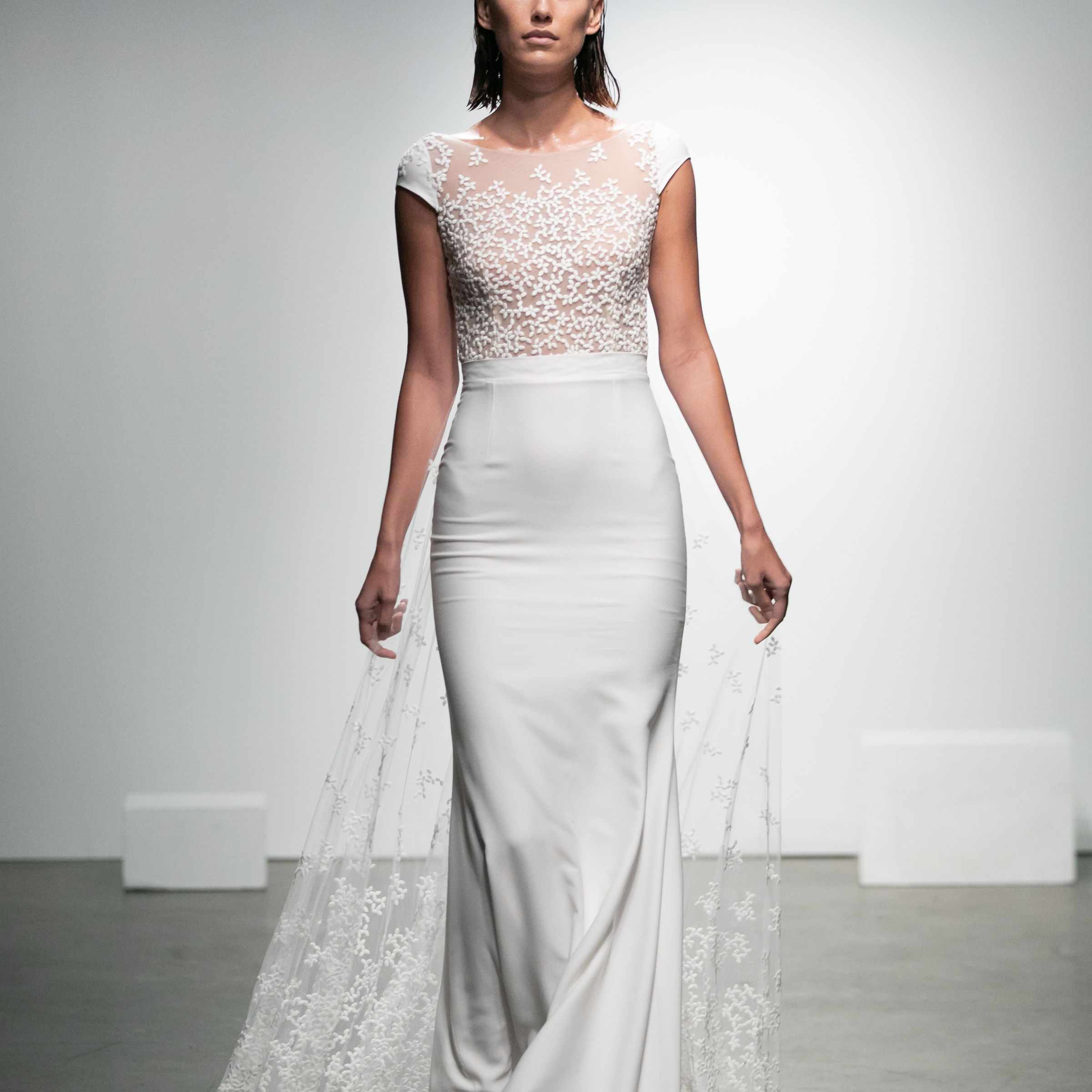 模特高领绉纱裙与帽袖和花卉刺绣薄纱裙