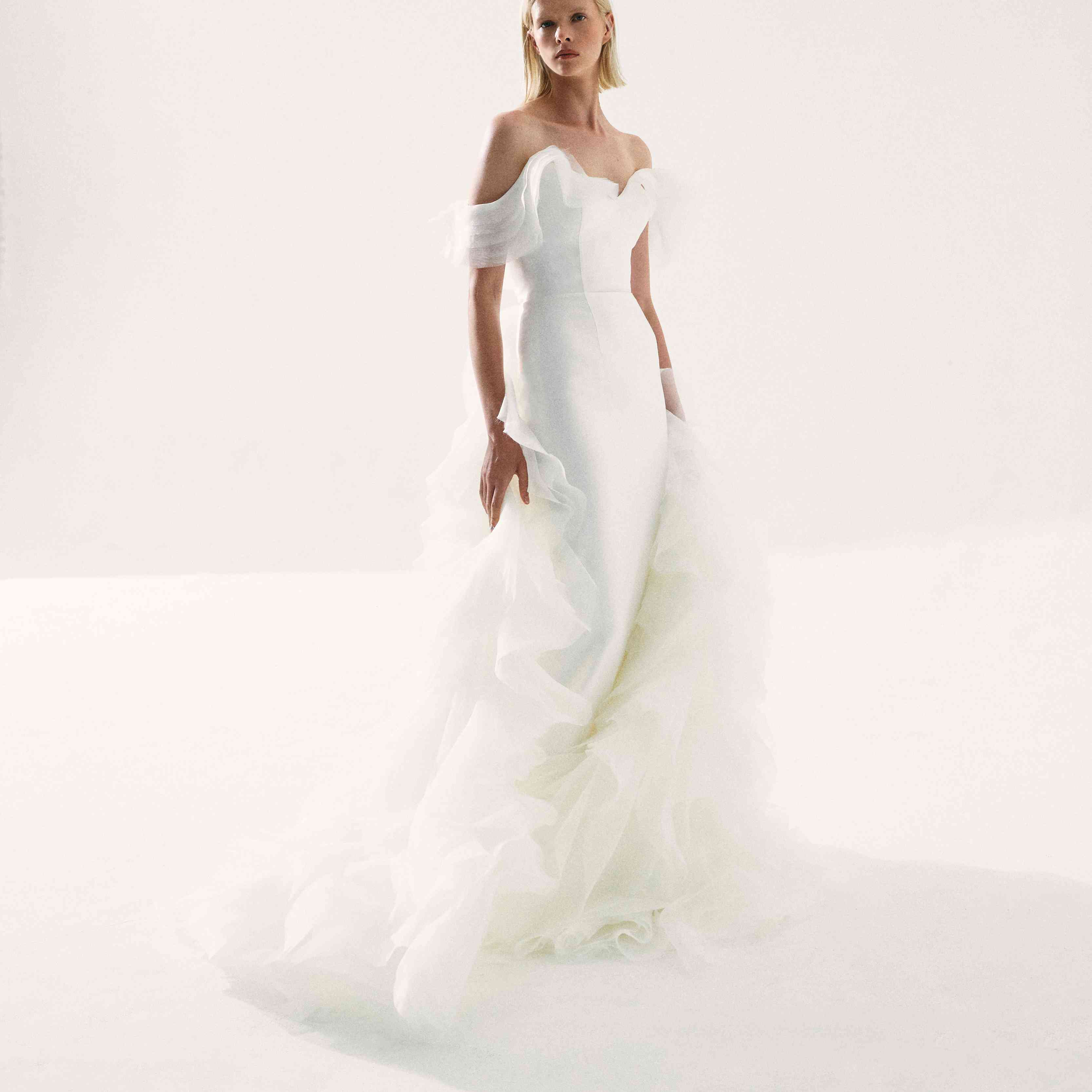 模特在露肩礼服与层叠褶边的拖尾