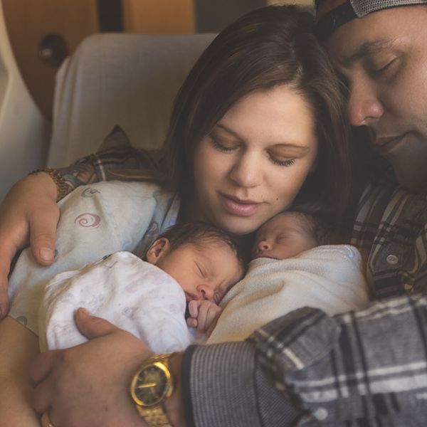 早产的异卵双胞胎与父母依偎在病床上