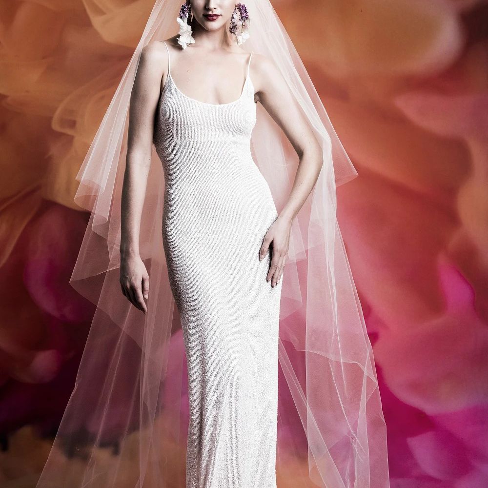 模特在合身的薄带闪闪发光的勺颈礼服