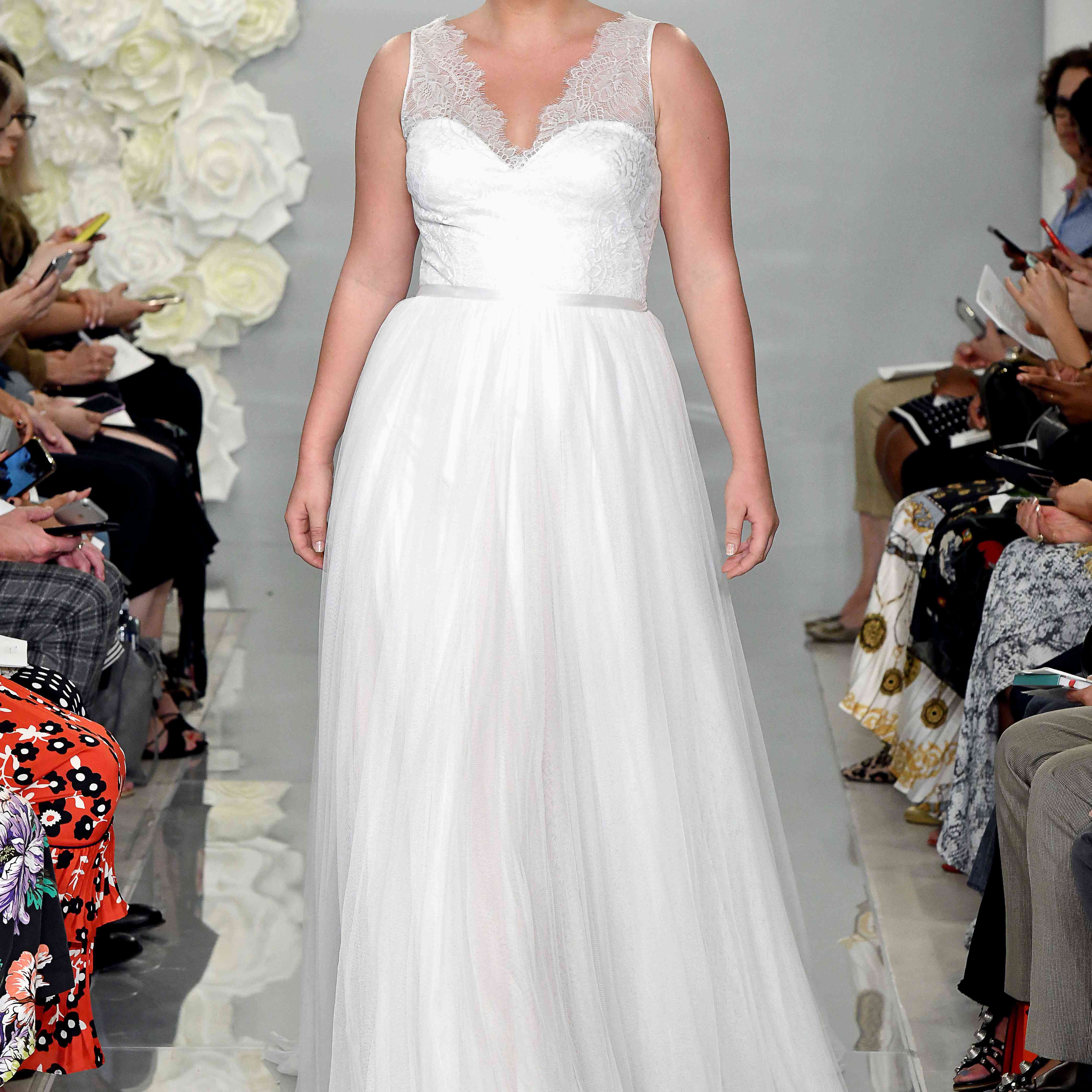 模型在跑道上v领薄纱lace-overlaid上衣的舞会礼服