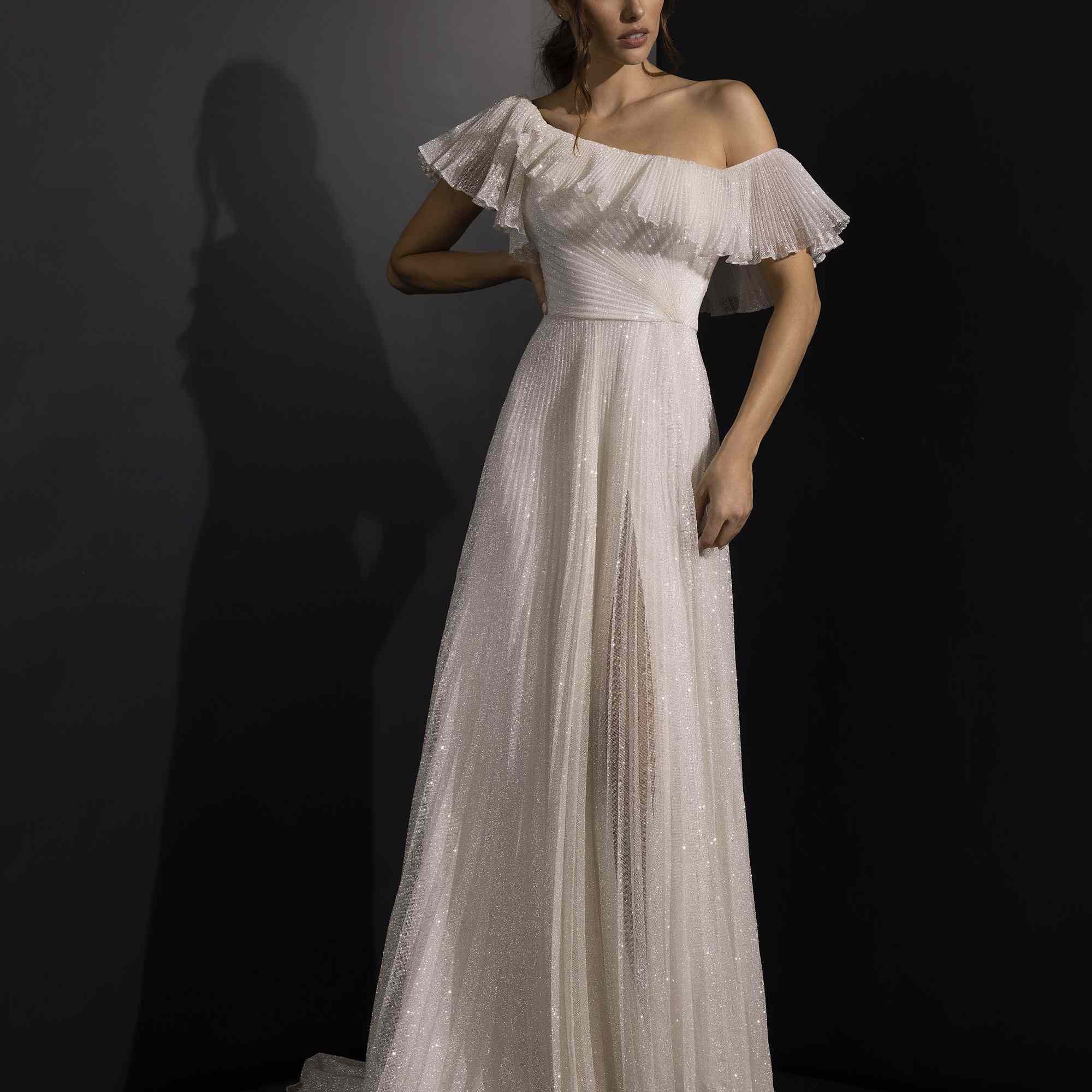 型号在不对称的肩部连衣裙，带有荷叶链