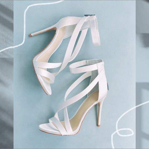 蓝色背景上白色系带高跟鞋的合成照片。