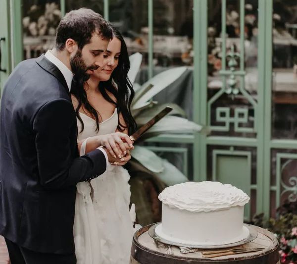 在花园婚礼新娘和新郎切割蛋糕