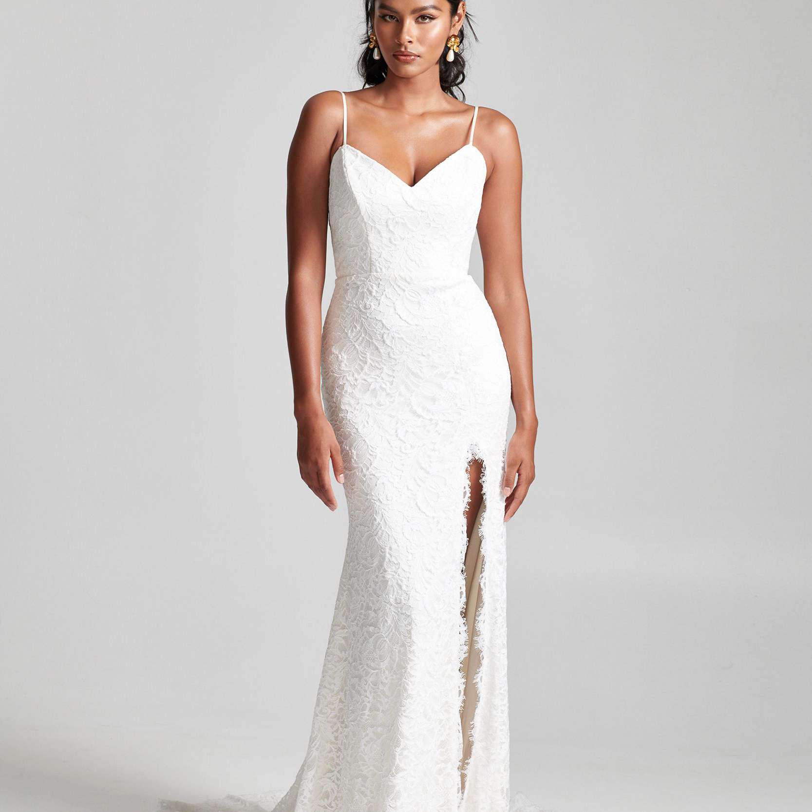 模特在花蕾丝连衣裙与扇形的裙子开叉