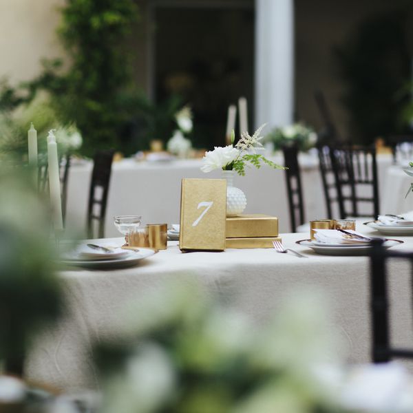 户外婚宴/晚宴上的餐桌。这张桌子配有餐具、花束和七号黄金装饰。