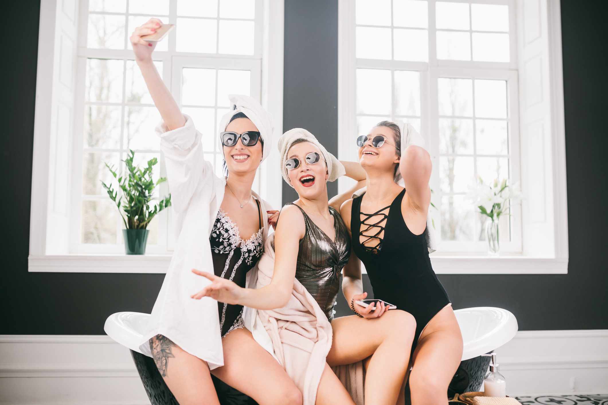 穿着泳衣的女孩和长袍在温泉拍摄自拍照