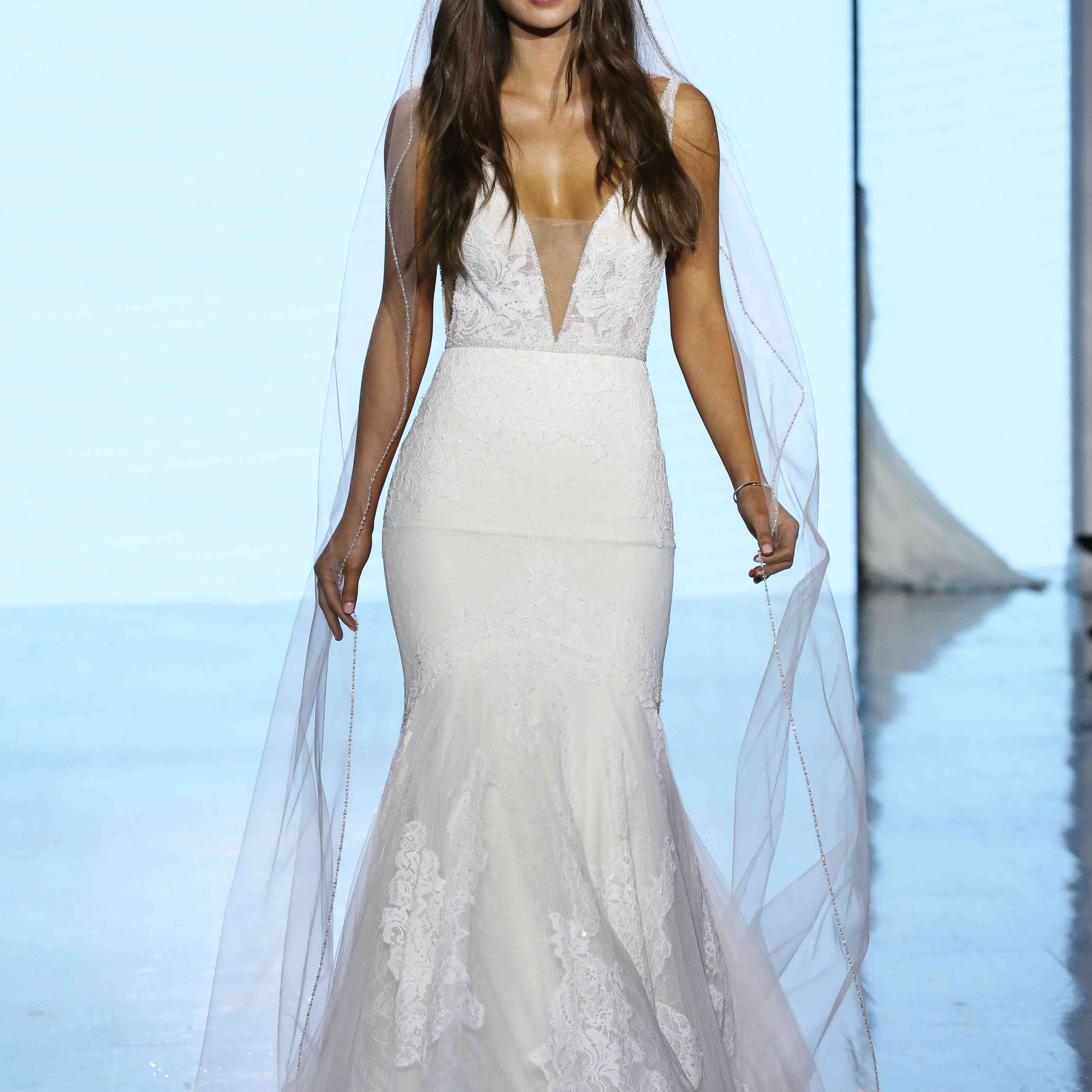 t台上的模特身着v领蕾丝碎花喇叭婚纱