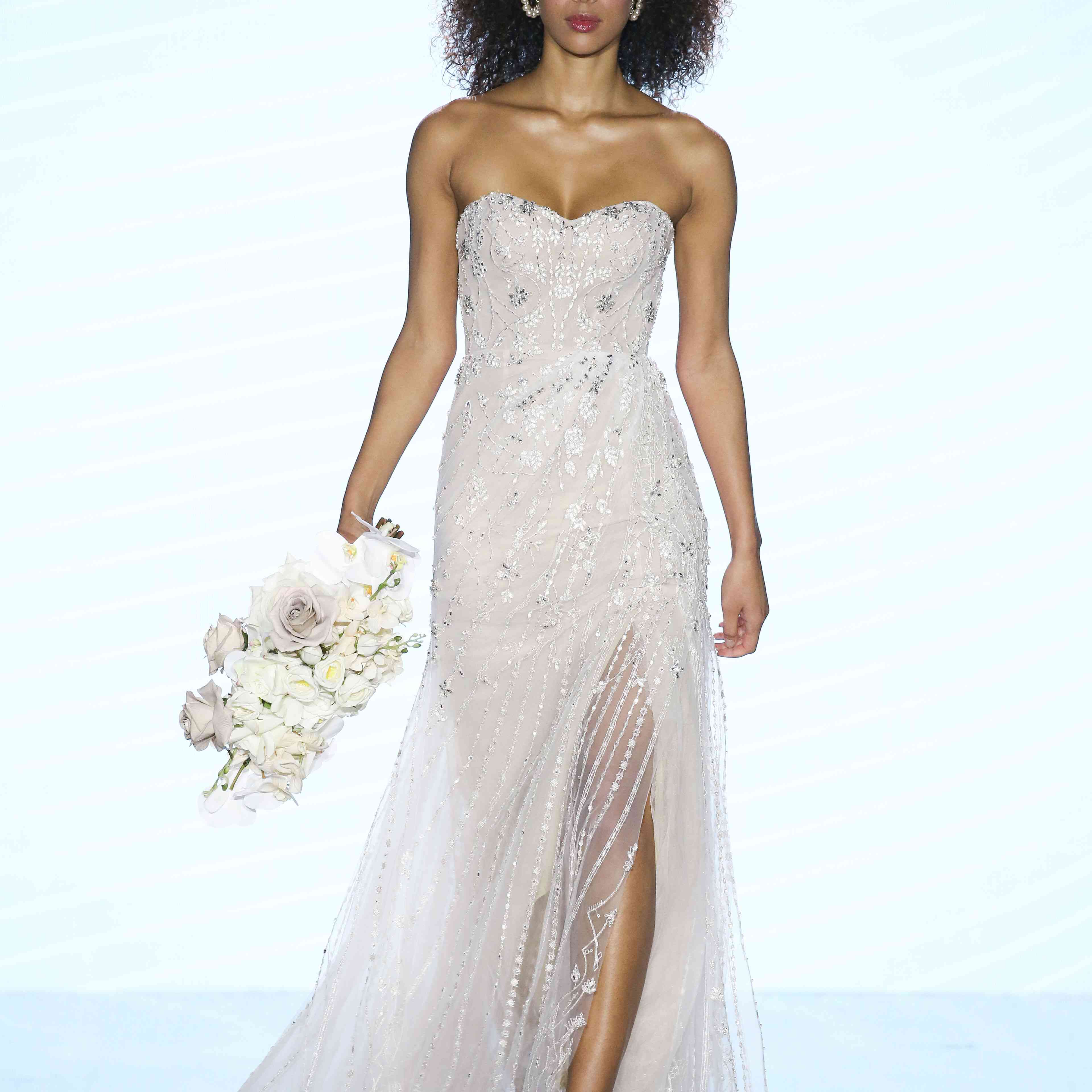 模特在无肩带的甜心结婚礼服与全银串珠和前开叉