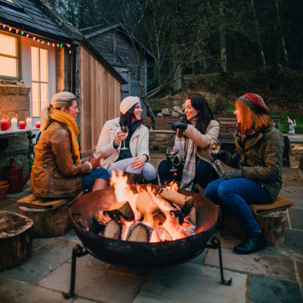 四个女人围着火坑喝酒