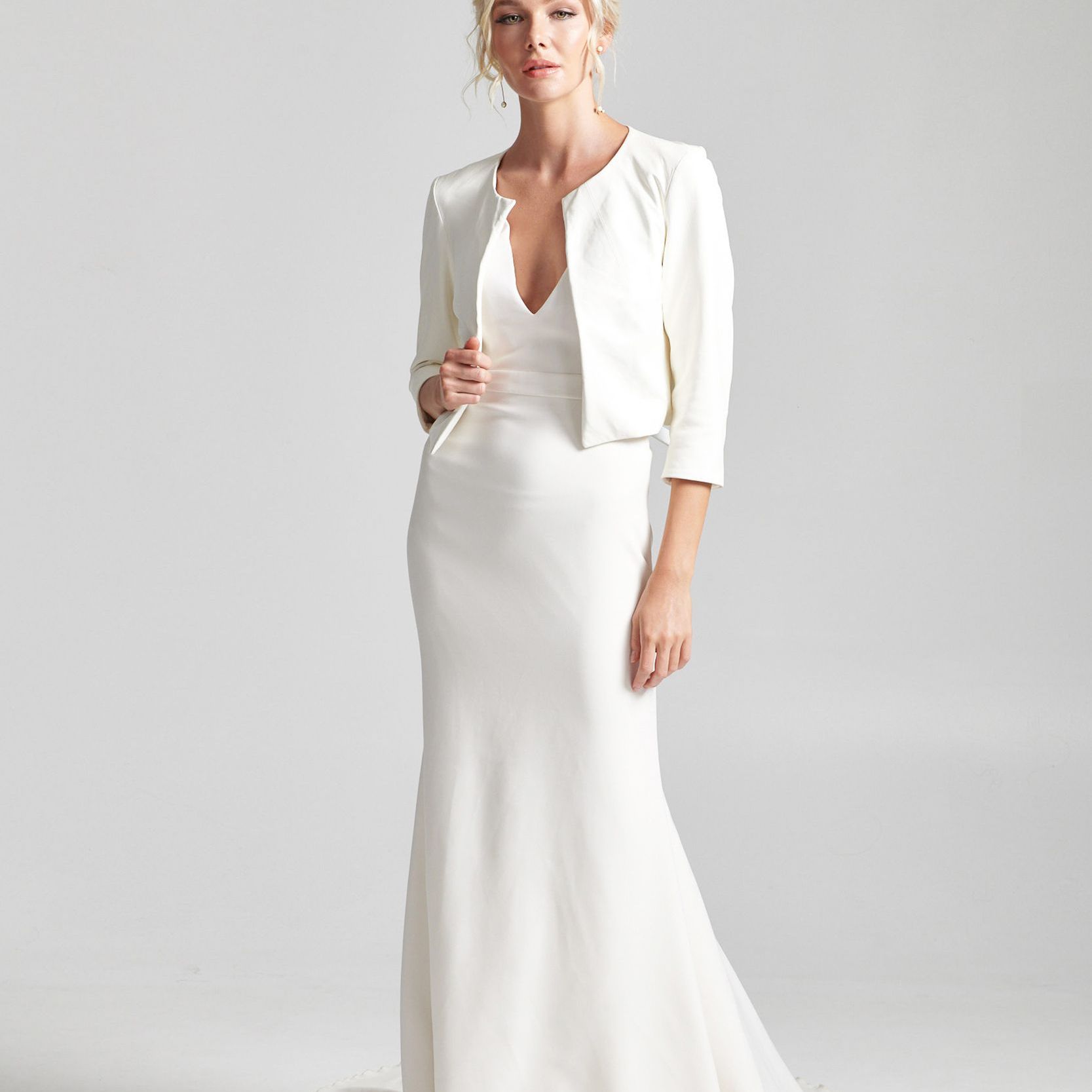 模特身穿v领婚纱搭配白色短夹克