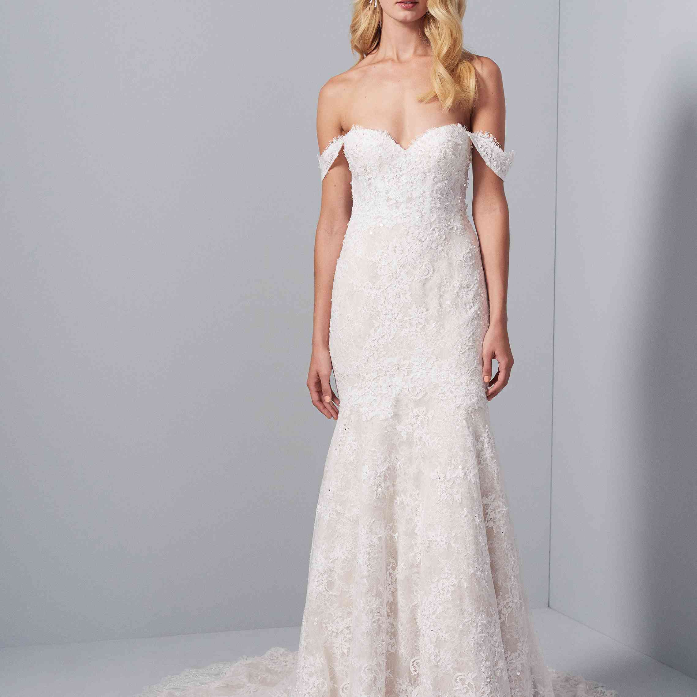 模特身穿乳白色蕾丝装饰的合身露肩礼服