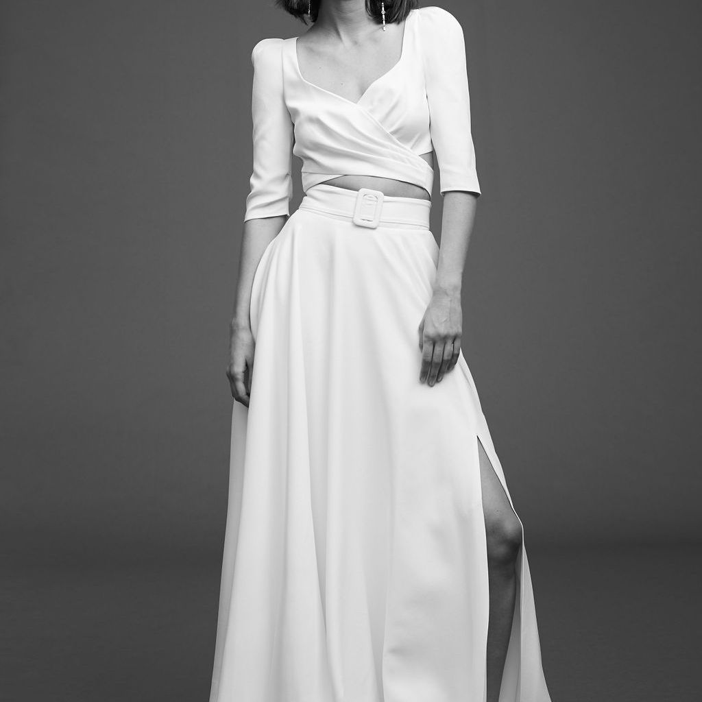 模特穿四分之三袖露脐上衣，搭配宽裙带和侧开叉