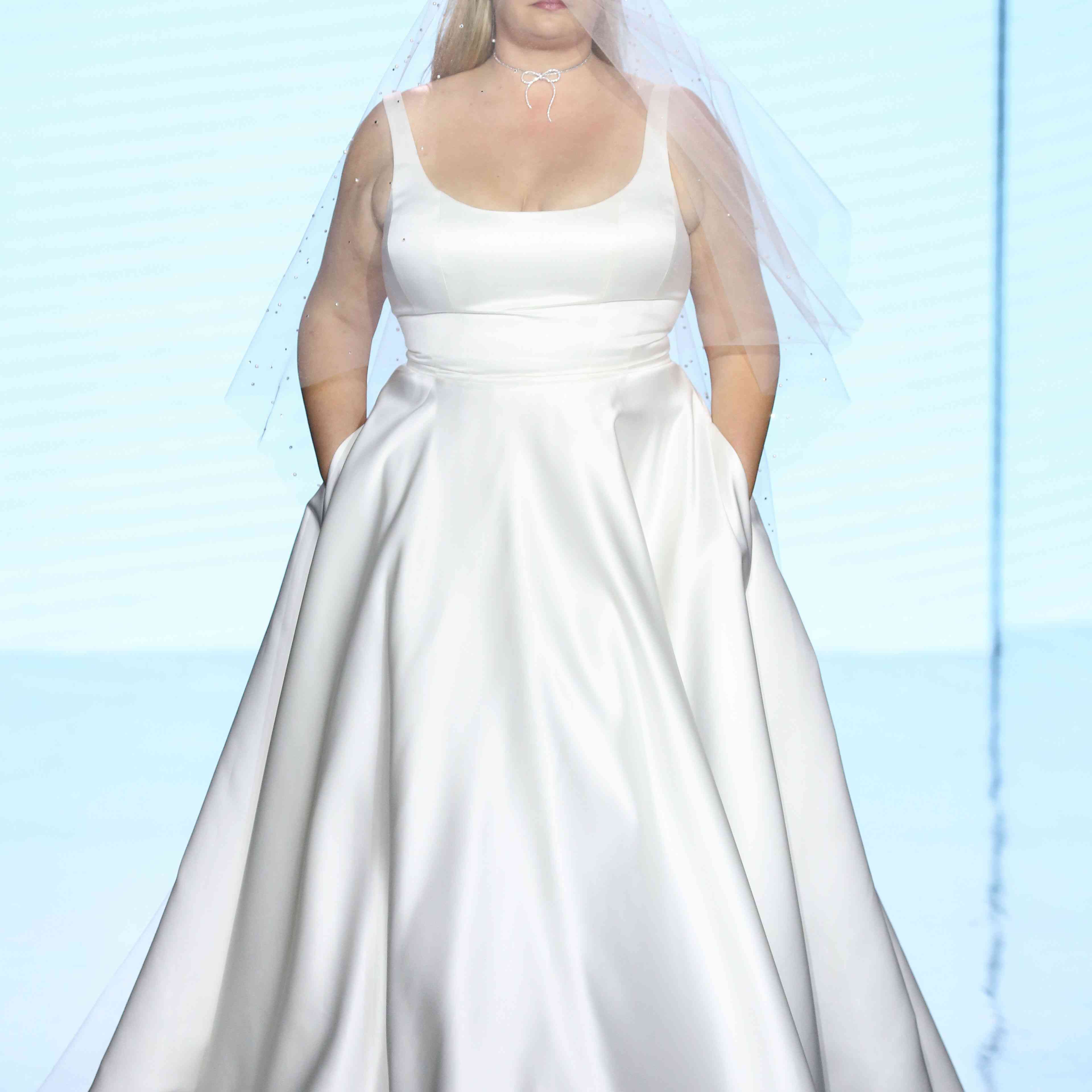 跑道模型在无袖勺脖子缎面裙子与裙子口袋